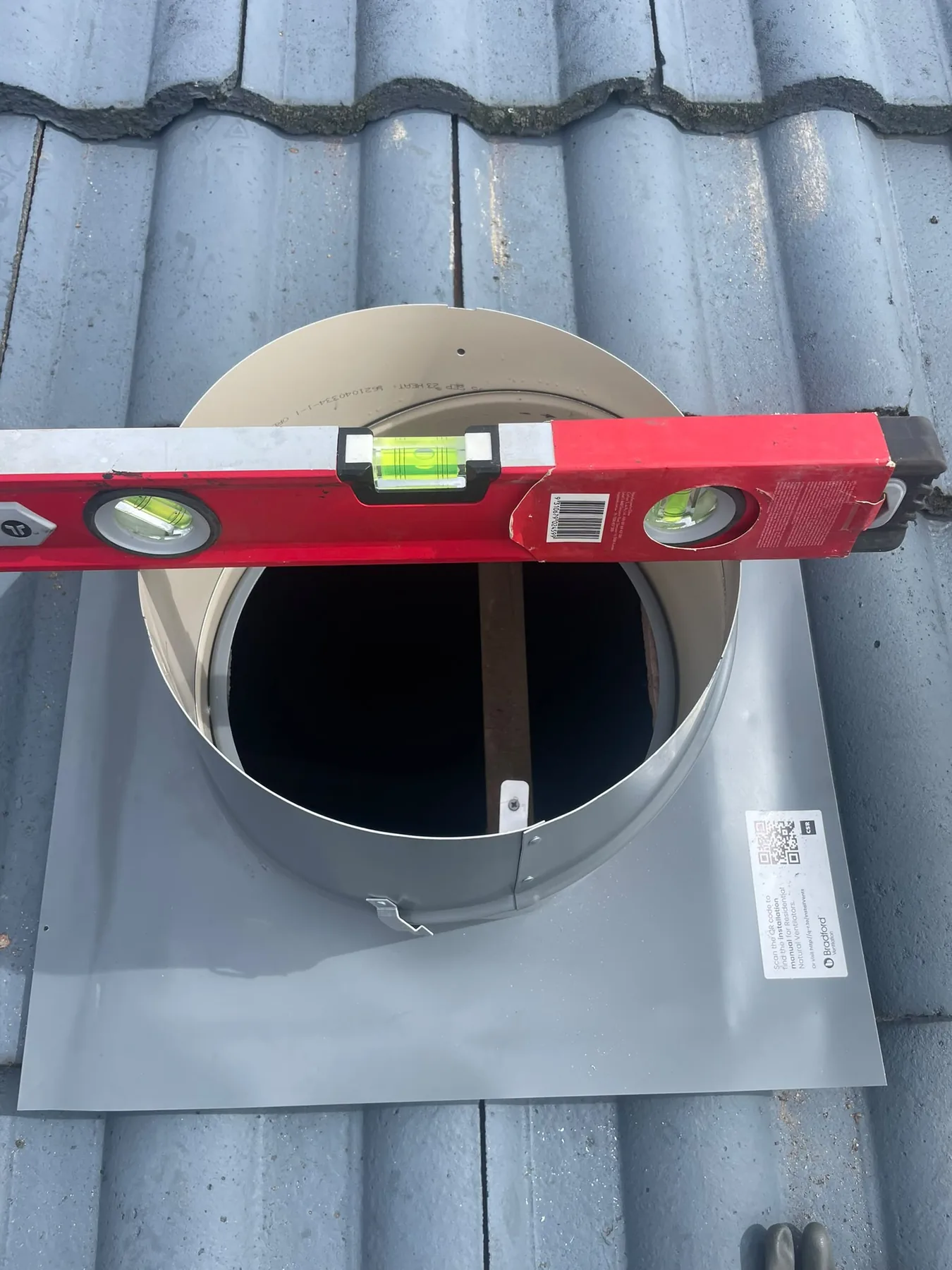 Roof ventilation installation detail being checked with a level